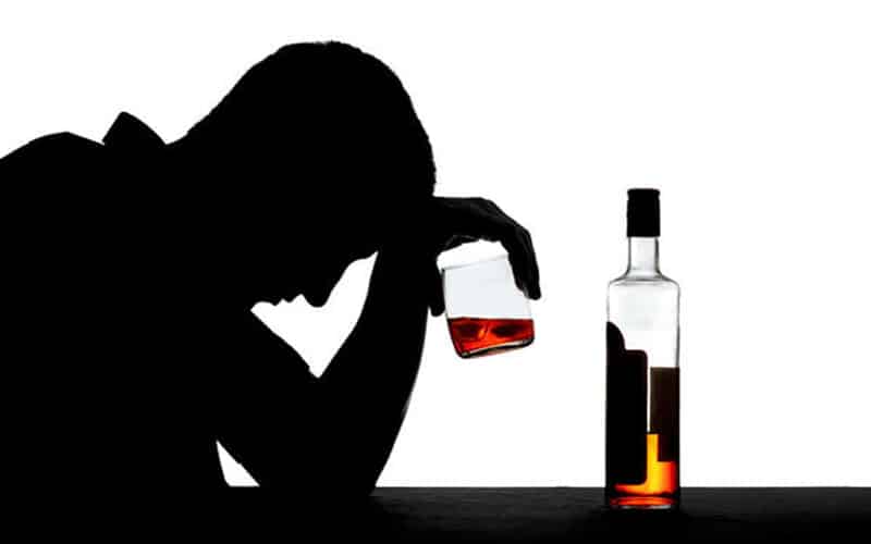 man sitting and drinking alcohol by himself
