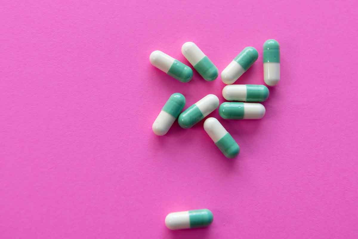 Blue drugs on a pink background. Drug and antidepressant crisis.