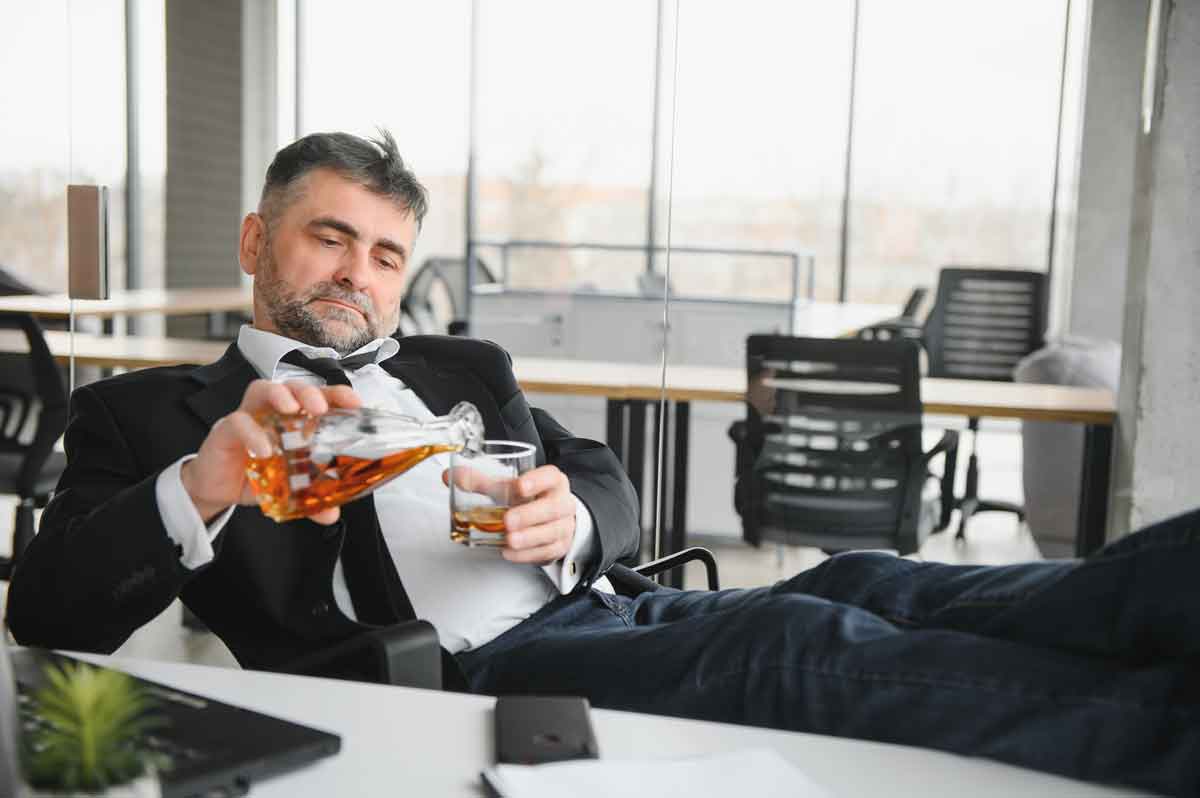 old businessman drinking from stress, sign of alcoholism, workaholism