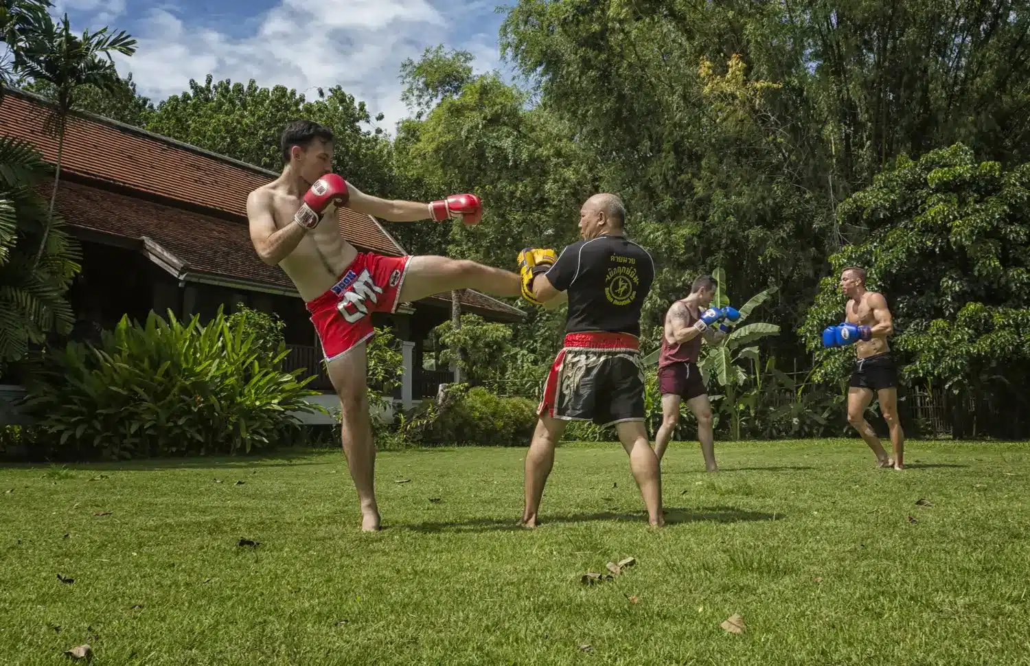 Four men training muaythai at the lawn at The Dawn.